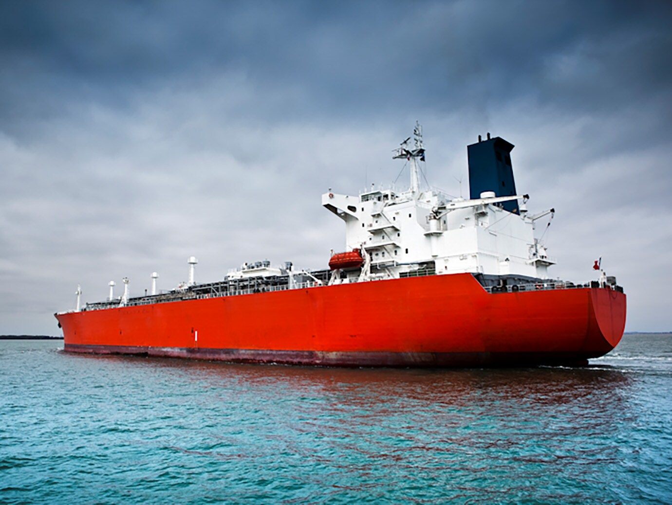 Red and white ship sailing on the water